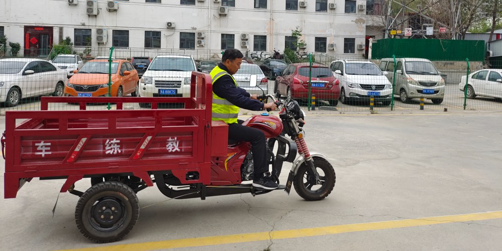 一个教练骑着三轮摩托车